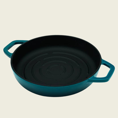 Teal cast iron bread pan on a beige background