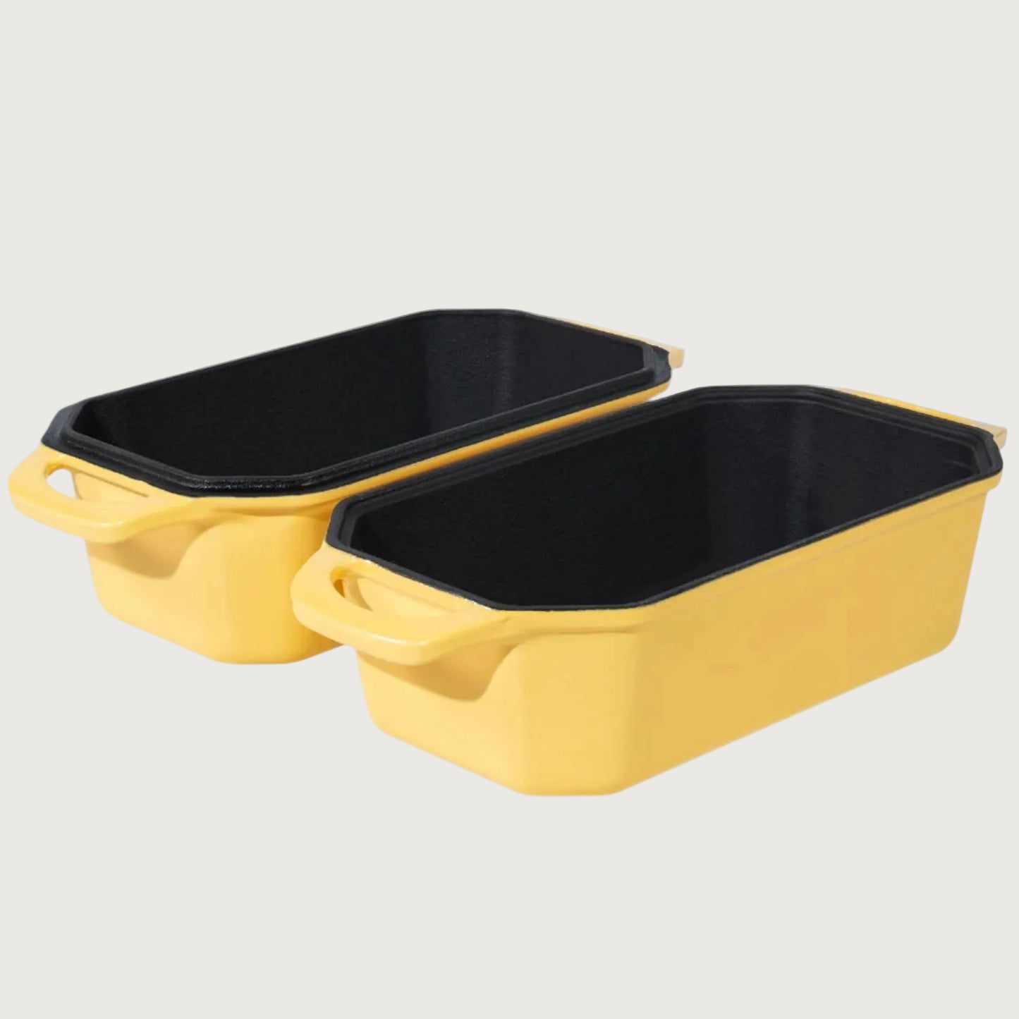 Two yellow baking dishes cast iron loaf pan with black interiors on a beige background