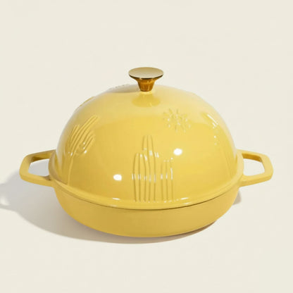Yellow cast iron dutch oven with a lid on a white background