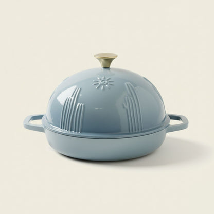 Light blue cast iron Dutch oven with lid on a beige background