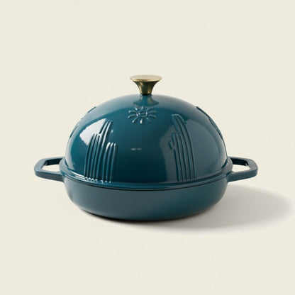 Teal enameled cast iron dome-shaped cookware on a beige background