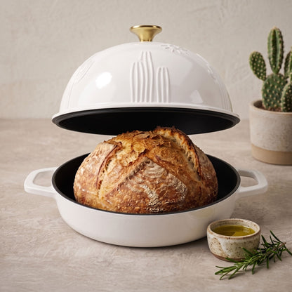 Enamelled cast iron Dutch oven in pearl white, open with sourdough loaf inside
