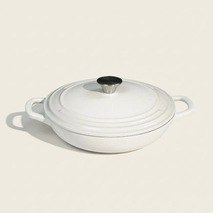 White enameled cast iron casserole dish with a lid on a beige background