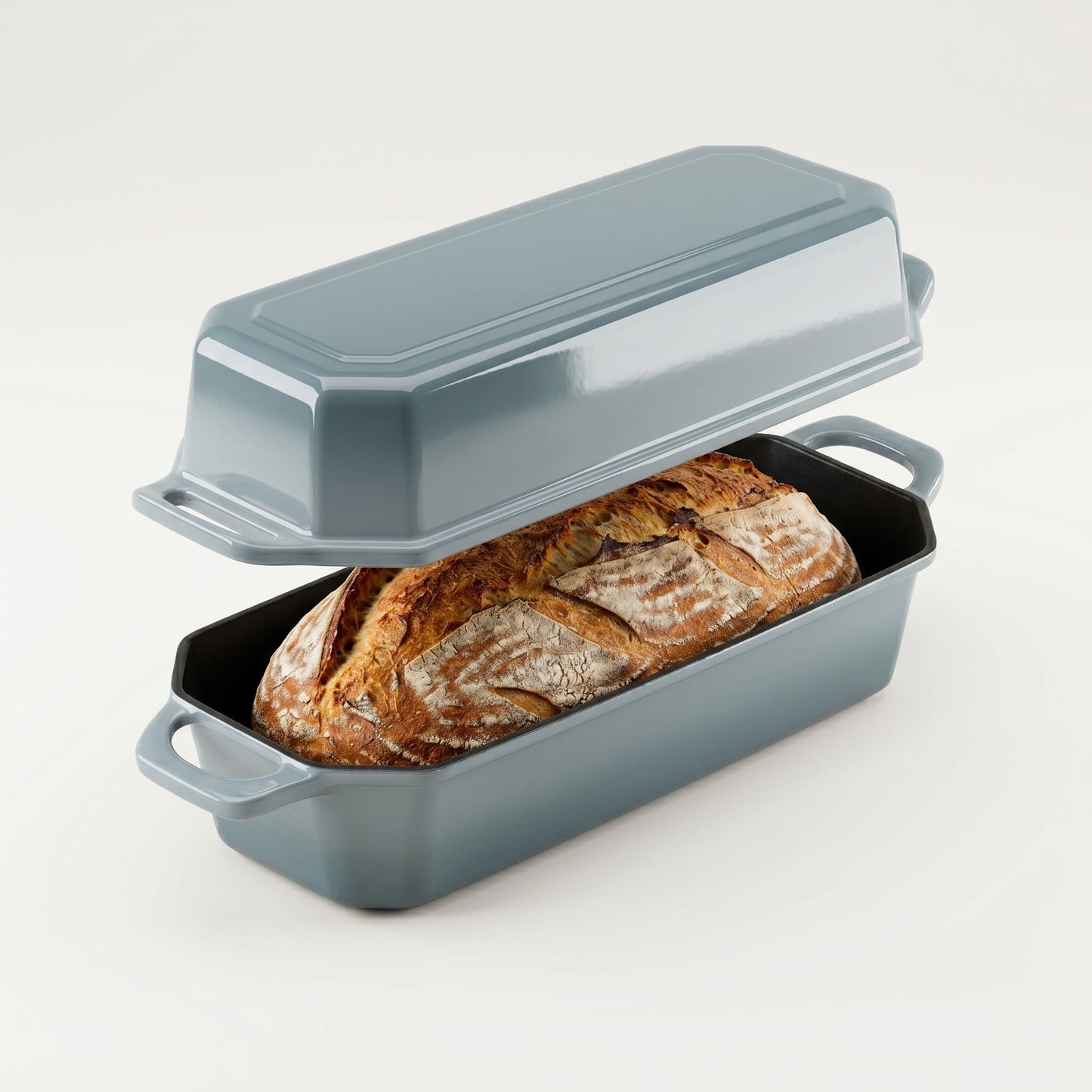 Gray bread loaf pan with a loaf of bread inside on a white background