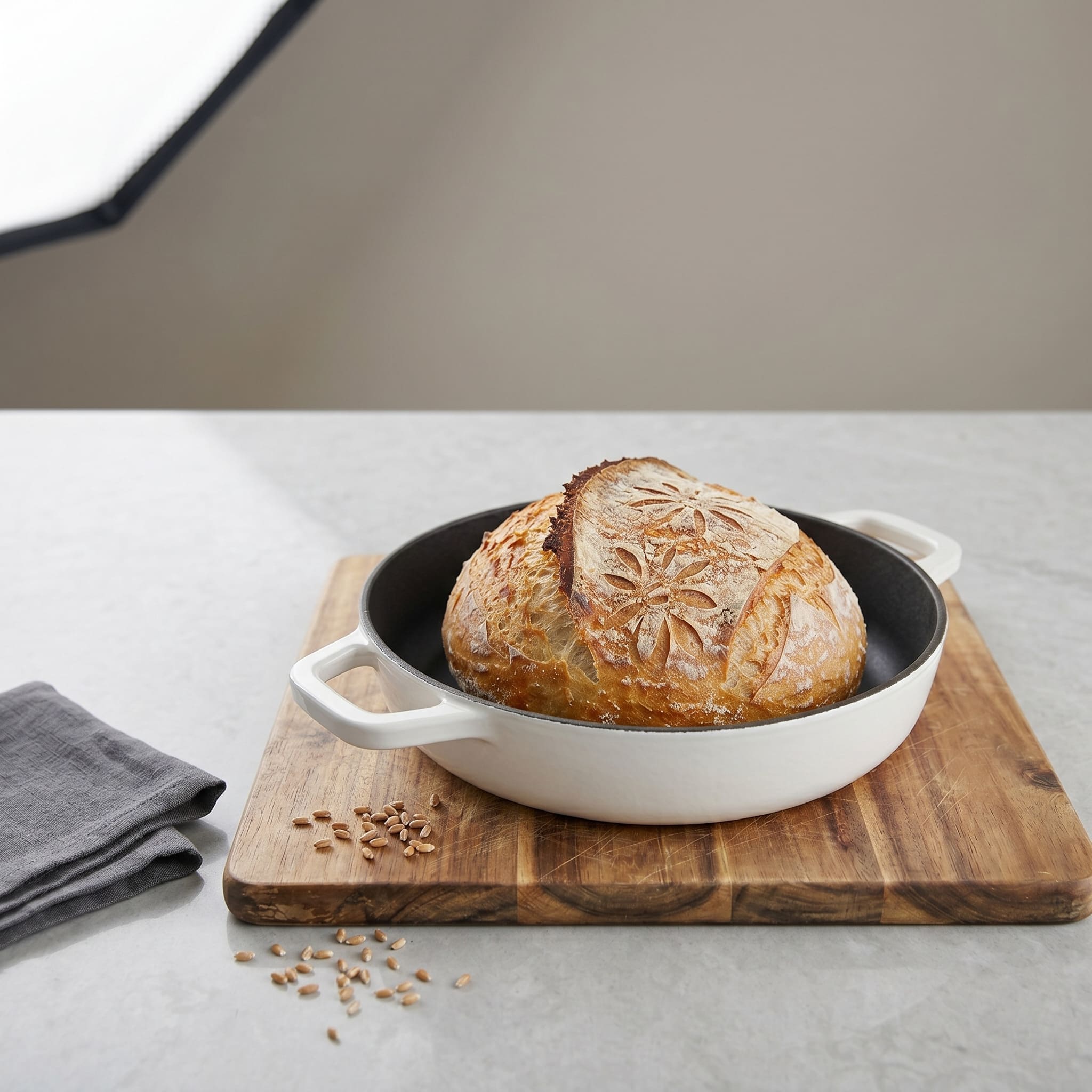 Enamelled cast iron Dutch oven with baked sourdough loaf inside