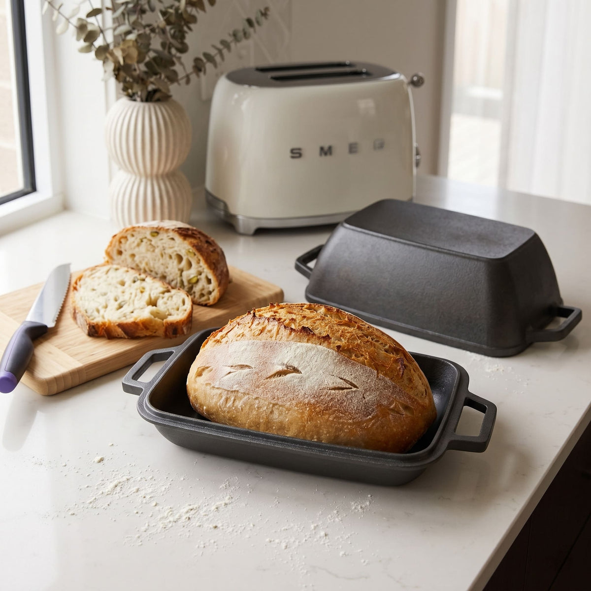 Oval bread oven on kitchen counter with a baked loaf and lid Black (Pre-Seasoned)