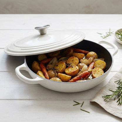 White casserole dish with roasted vegetables on a wooden surface