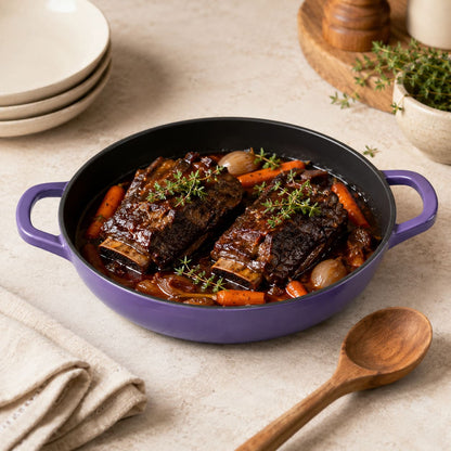 iris purple enamelled cast iron shallow casserole dish with two side handles, filled with stew
