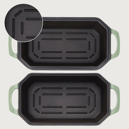 Two loaf pans with green handles on a white background, highlighting the design for easier bread removal.