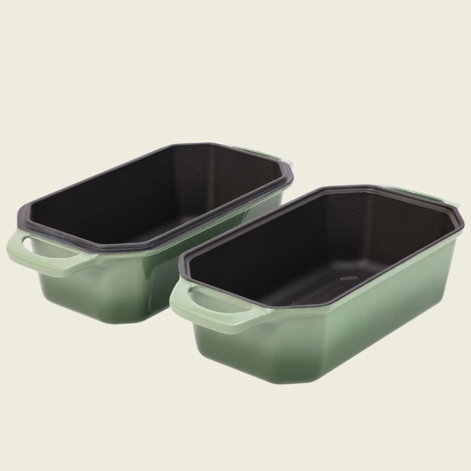Two green rectangular baking pans with black interior on a white background