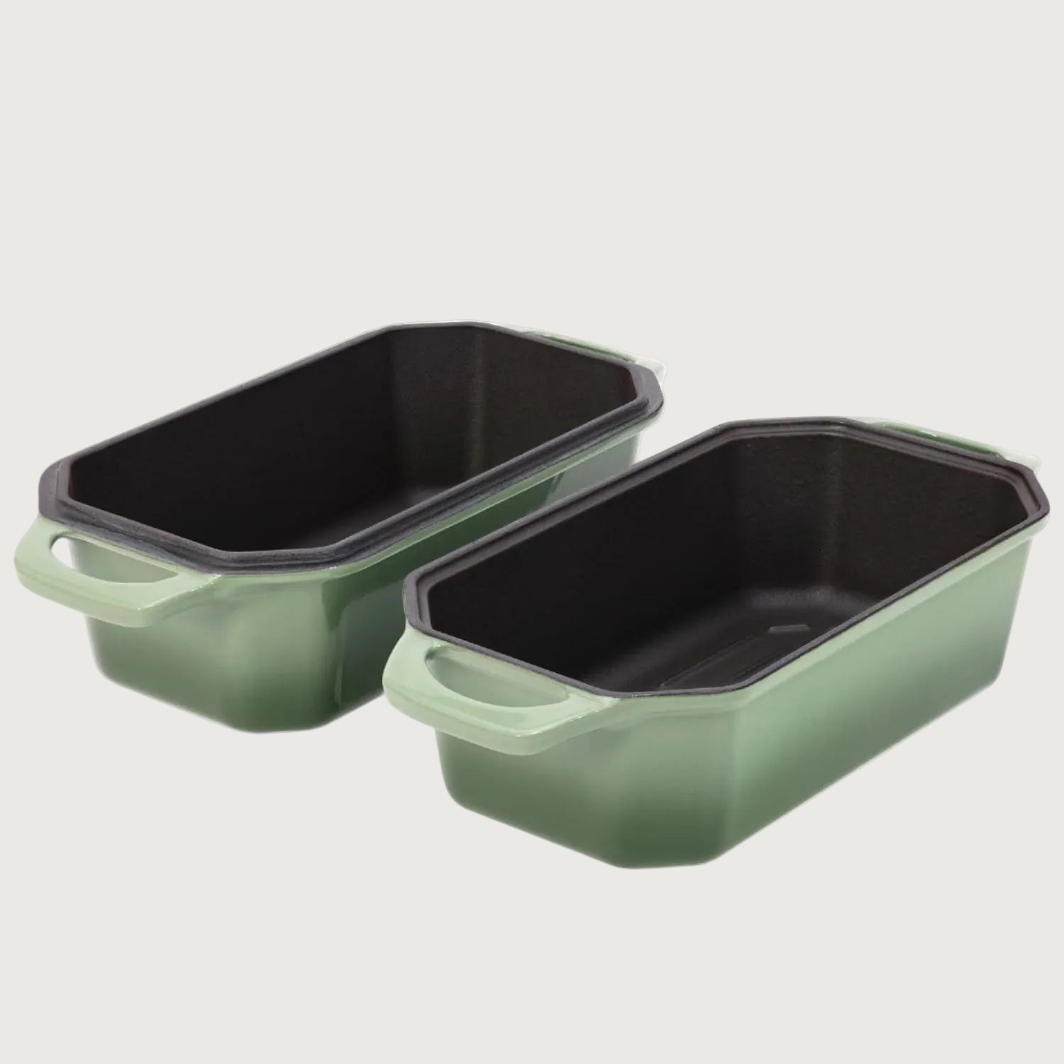 Two green rectangular baking loaf pans with black interior on a white background