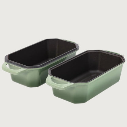 Two green rectangular baking loaf pans with black interior on a white background
