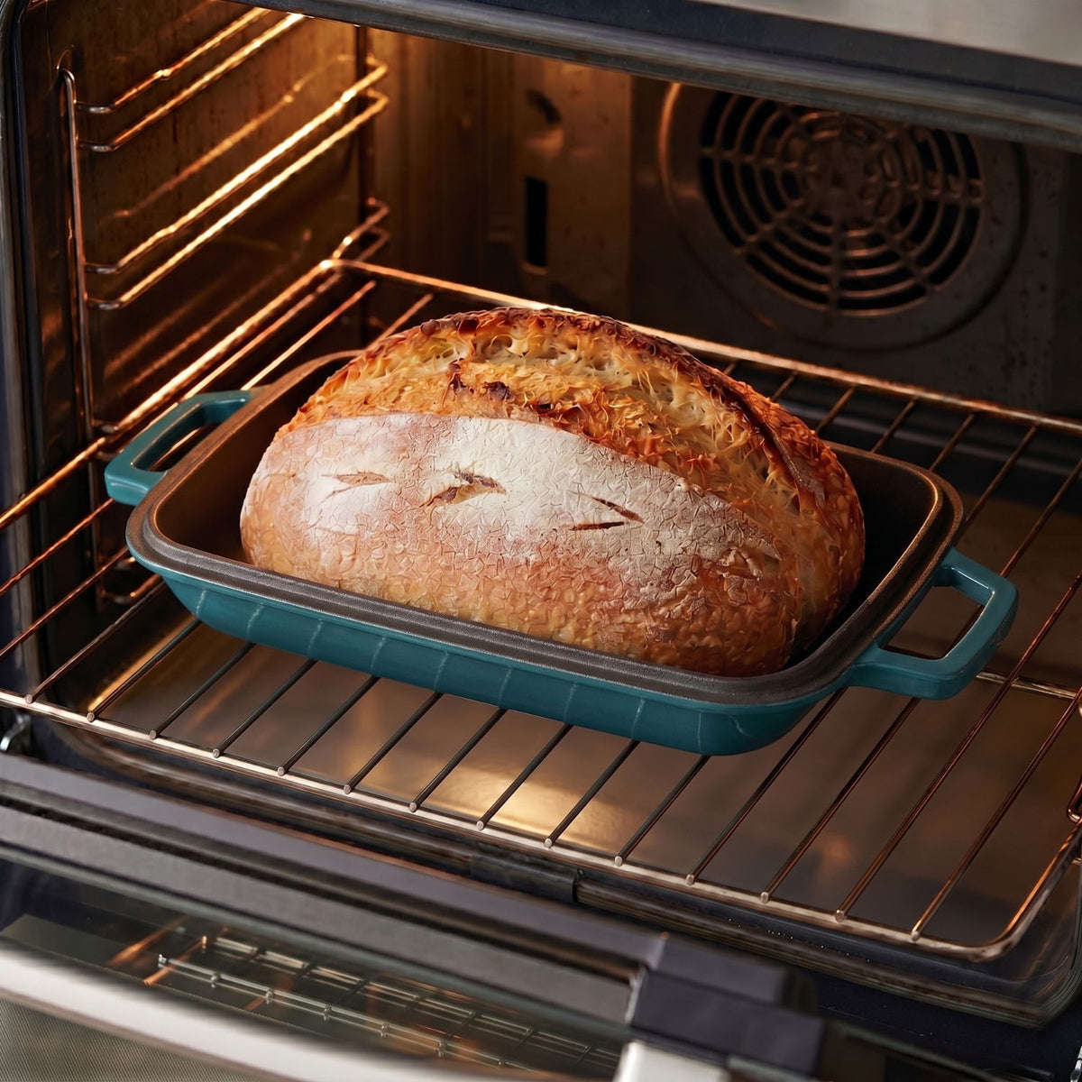 Oval bread oven with baked loaf, teal base on oven rack Deep Cyan (enamelled)
