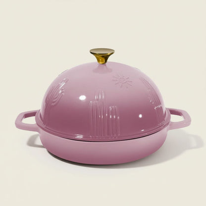 Pink round bread baker with a dome lid on a beige background
