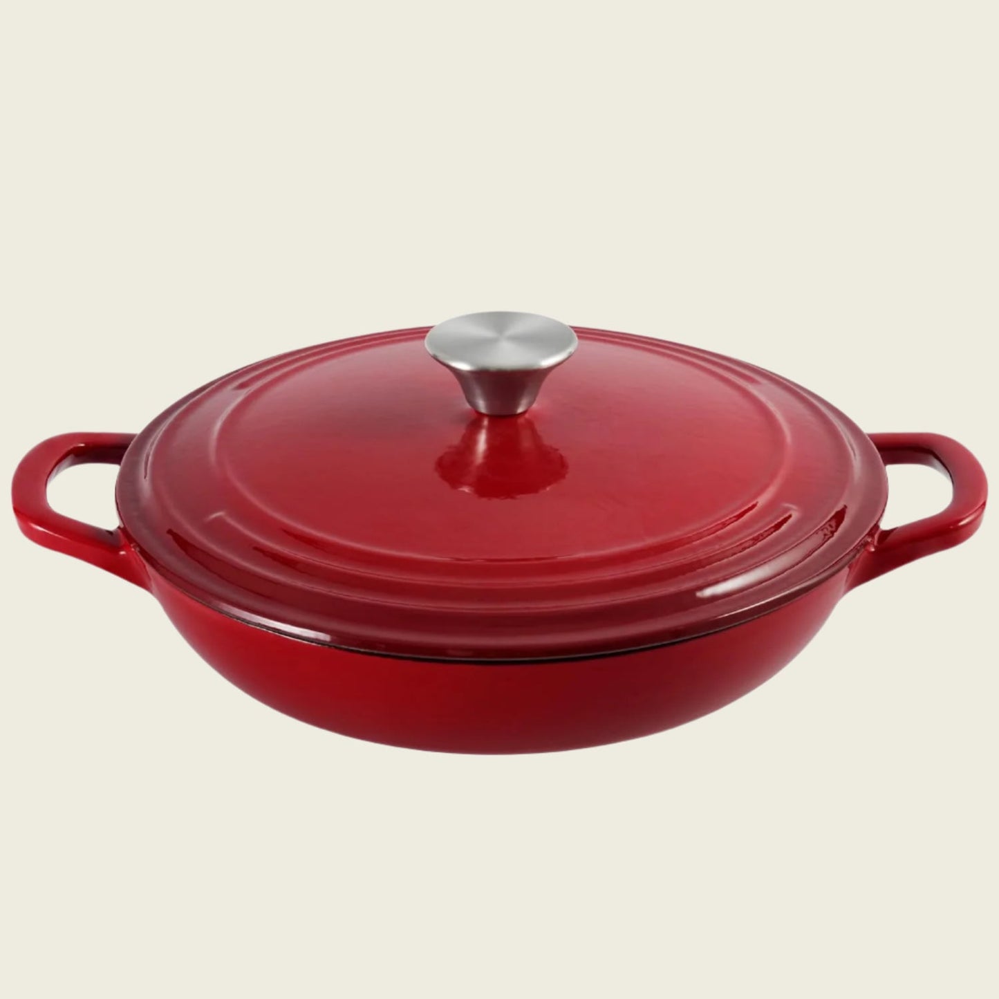 A red enameled cast iron braiser with a lid, featuring a round shape and two handles.