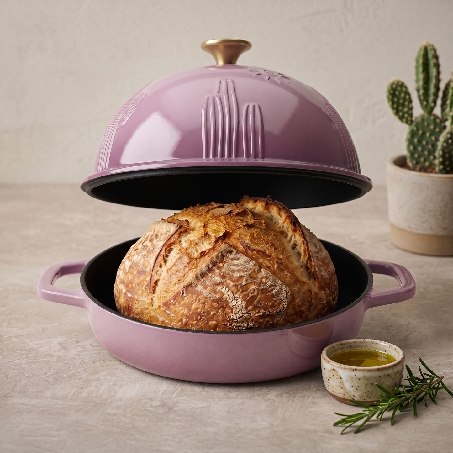 Enamelled cast iron Dutch oven in rose pink, open with sourdough loaf inside