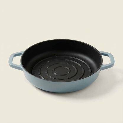 Blue cast iron bread pan with black interior on a beige background