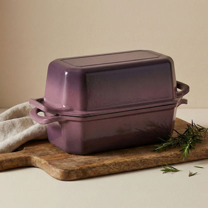 Purple rectangular baking dish bread loaf pan on a wooden cutting board with a beige background