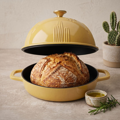 Enamelled cast iron Dutch oven in sunny yellow, open with sourdough loaf inside